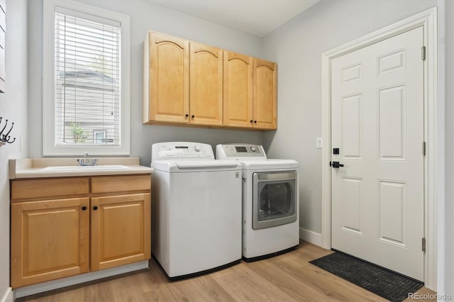 10029 Winterthur Ct, Highlands Ranch, CO 80129 - laundry area featuring washing machine and clothes dryer, cabinet space, light wood-type flooring, and a sink