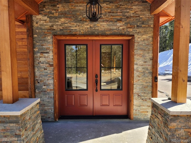 property entrance featuring french doors and stone siding