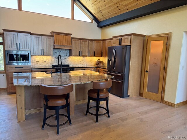 14564 Reserve Rd, Pine, CO 80470 - kitchen featuring fridge with ice dispenser, stainless steel microwave, wood ceiling, stone countertops, and a breakfast bar area
