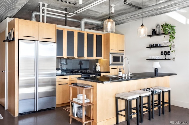 kitchen with dark countertops, appliances with stainless steel finishes, tasteful backsplash, open shelves, and a sink