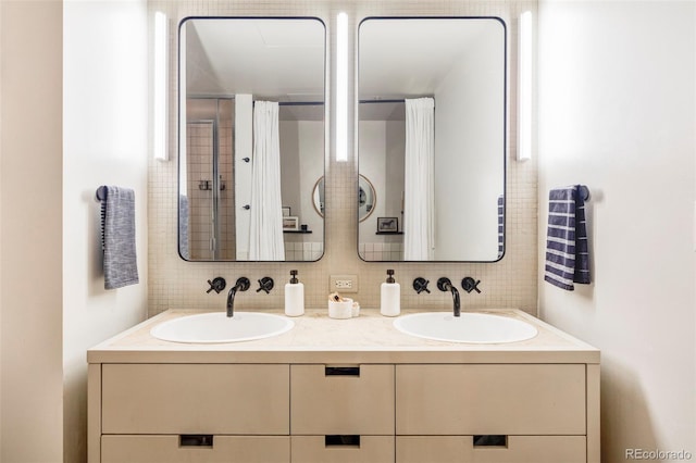 full bath featuring a sink, tasteful backsplash, and double vanity