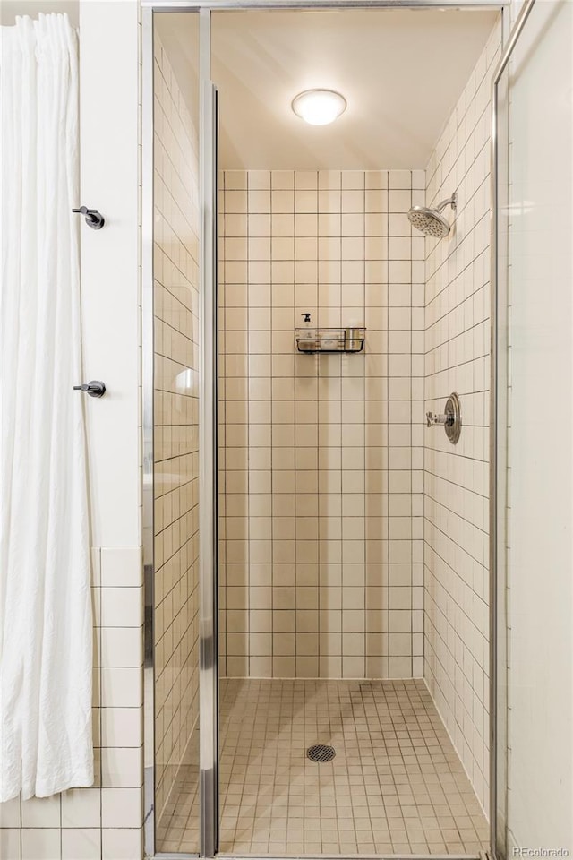 full bathroom with tile patterned flooring and a shower stall