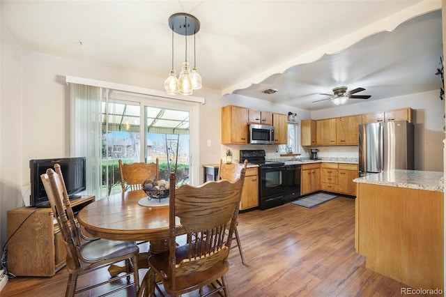 dining room with ceiling fan with notable chandelier and wood finished floors