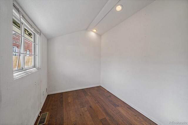 unfurnished room featuring baseboards, visible vents, lofted ceiling, and hardwood / wood-style floors
