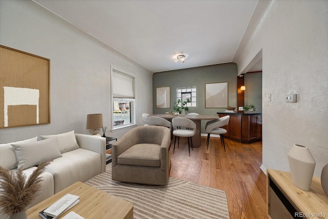 living area featuring a textured wall and light wood finished floors