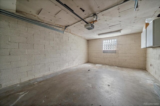 garage with concrete block wall and a garage door opener