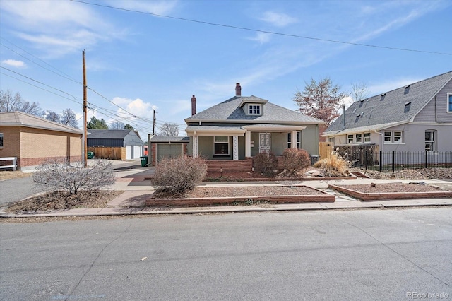 view of front of property with a chimney, fence, a garage, and an outbuilding