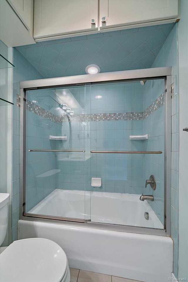 full bathroom with tile patterned floors, toilet, and shower / bath combination with glass door