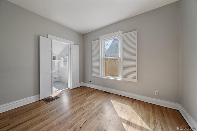 unfurnished bedroom featuring baseboards, visible vents, and light wood-style floors