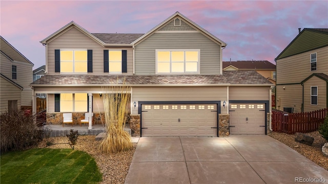 10158 Granby St, Commerce City, CO 80022 - traditional-style home with a porch, driveway, fence, a shingled roof, and stone siding