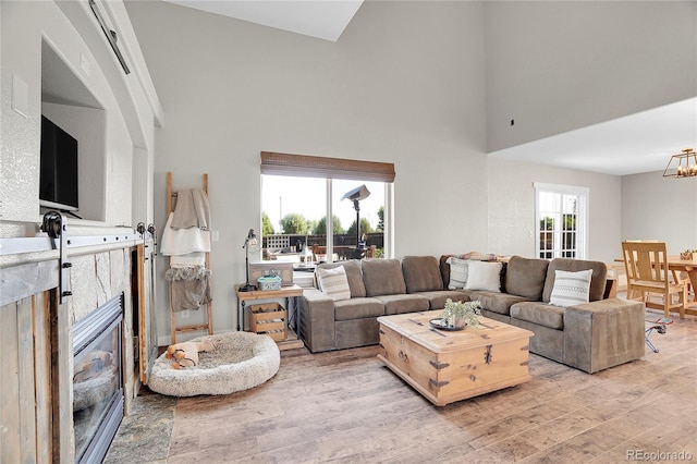 10521 Taylor Ave, Firestone, CO 80504 - living room featuring a towering ceiling, light wood-type flooring, and a chandelier