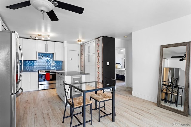 1121 Albion St Unit 210, Denver, CO 80220 - kitchen featuring stainless steel appliances, ceiling fan, light wood-style floors, and dark countertops