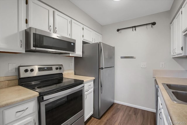 519 Wright St Unit 108, Lakewood, CO 80228 - kitchen with stainless steel appliances, dark wood-style floors, white cabinets, and light countertops