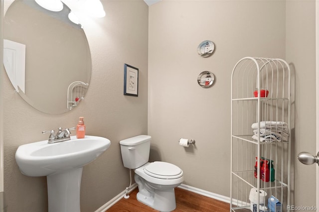 bathroom with toilet and hardwood / wood-style floors