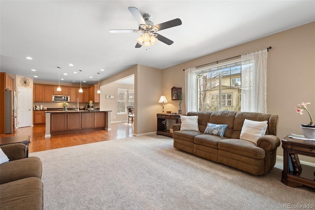 carpeted living room featuring ceiling fan