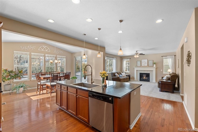 kitchen with sink, hanging light fixtures, a center island with sink, stainless steel dishwasher, and light hardwood / wood-style floors