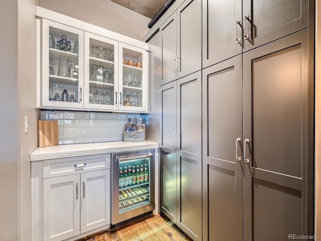 1401 Wewatta St Unit 308, Denver, CO 80202 - indoor dry bar with wine cooler, backsplash, and light wood-style floors