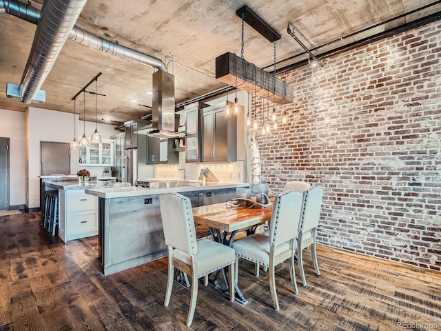 1401 Wewatta St Unit 308, Denver, CO 80202 - kitchen with dark wood finished floors, light countertops, brick wall, a peninsula, and a center island