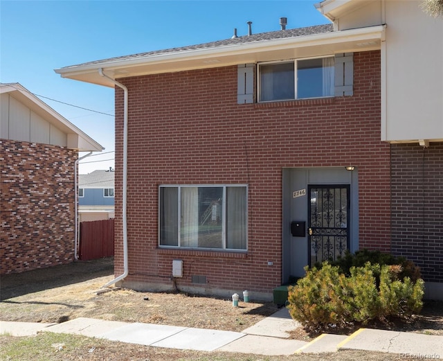 traditional-style house featuring fence, brick siding, and crawl space