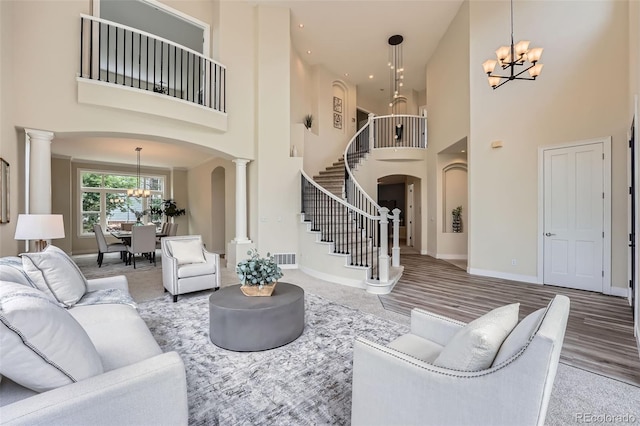 22019 E Arbor Dr, Aurora, CO 80016 - living area featuring a chandelier, arched walkways, a towering ceiling, stairs, and ornate columns
