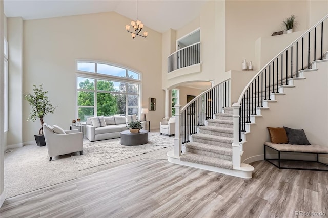 22019 E Arbor Dr, Aurora, CO 80016 - foyer entrance with high vaulted ceiling, stairs, wood finished floors, a chandelier, and arched walkways