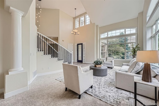 22019 E Arbor Dr, Aurora, CO 80016 - living area with decorative columns, a high ceiling, stairs, a chandelier, and carpet