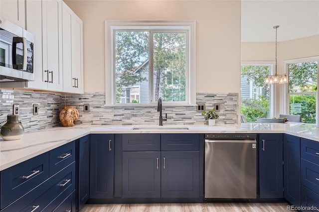 22019 E Arbor Dr, Aurora, CO 80016 - kitchen featuring appliances with stainless steel finishes, blue cabinetry, white cabinets, and backsplash