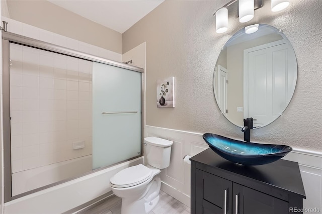 22019 E Arbor Dr, Aurora, CO 80016 - bathroom featuring vanity, a wainscoted wall, enclosed tub / shower combo, a decorative wall, and wood finished floors