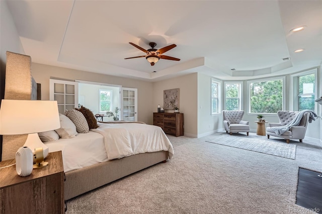 22019 E Arbor Dr, Aurora, CO 80016 - carpeted bedroom featuring a tray ceiling, multiple windows, and a ceiling fan