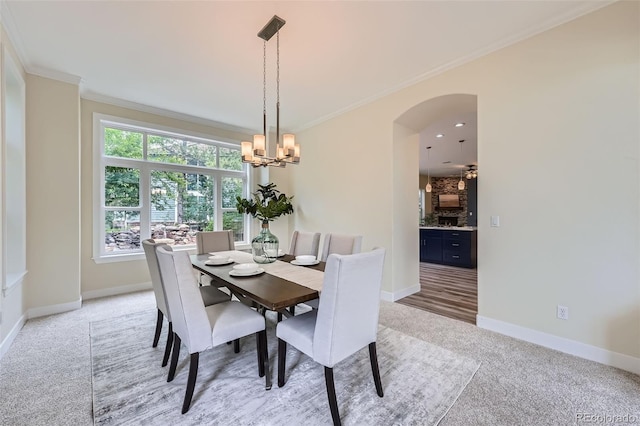 22019 E Arbor Dr, Aurora, CO 80016 - dining space with light colored carpet, ornamental molding, a chandelier, and arched walkways