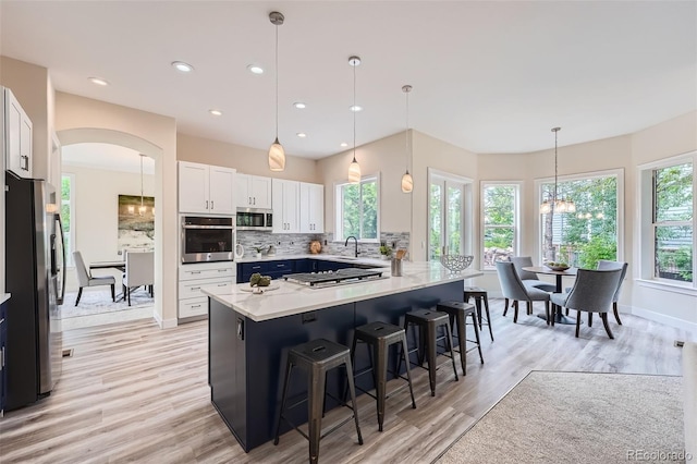 22019 E Arbor Dr, Aurora, CO 80016 - kitchen with appliances with stainless steel finishes, a kitchen bar, light countertops, plenty of natural light, and recessed lighting
