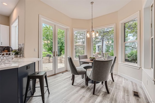 22019 E Arbor Dr, Aurora, CO 80016 - dining area featuring a chandelier, healthy amount of natural light, and light wood-style floors