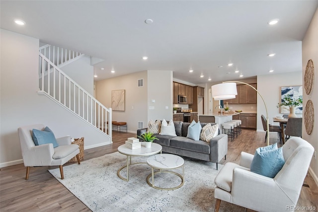 living room with sink and light hardwood / wood-style floors