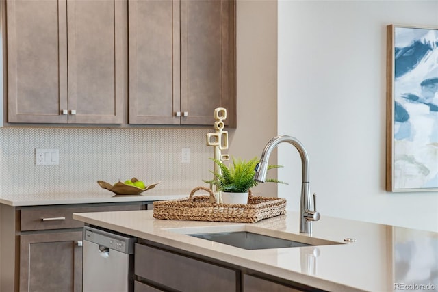 kitchen with light stone counters, sink, decorative backsplash, and stainless steel dishwasher