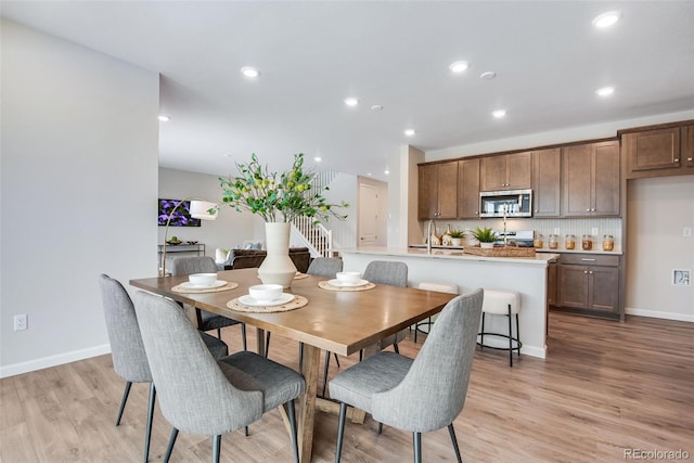 dining room with sink and light hardwood / wood-style flooring