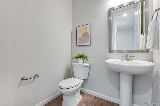 bathroom featuring wood-type flooring and toilet