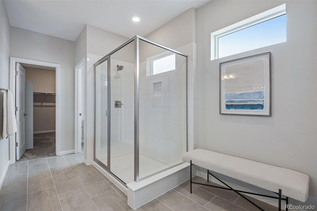 bathroom with a shower with shower door and tile patterned flooring