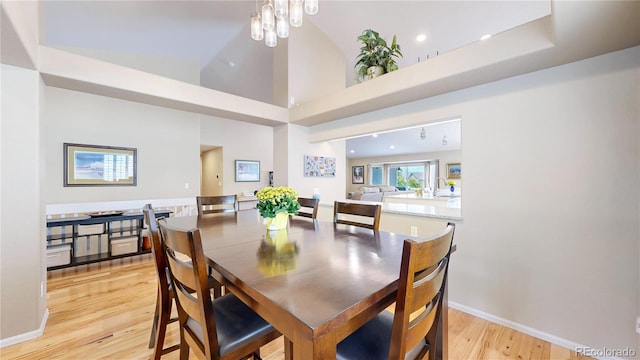 14833 Vine St, Thornton, CO 80602 - dining space featuring light wood finished floors, a towering ceiling, and baseboards