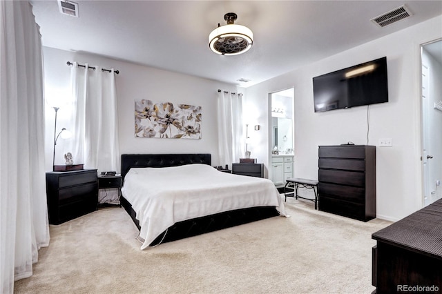 carpeted bedroom featuring visible vents and connected bathroom