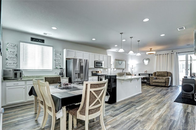 dining room with recessed lighting, visible vents, and wood finished floors