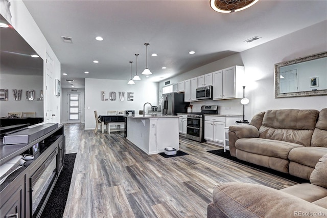 kitchen featuring open floor plan, appliances with stainless steel finishes, visible vents, and white cabinetry