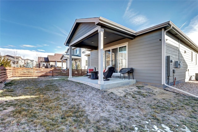 rear view of property with fence and a patio