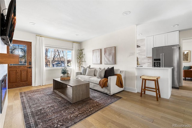 living room with light hardwood / wood-style floors and sink