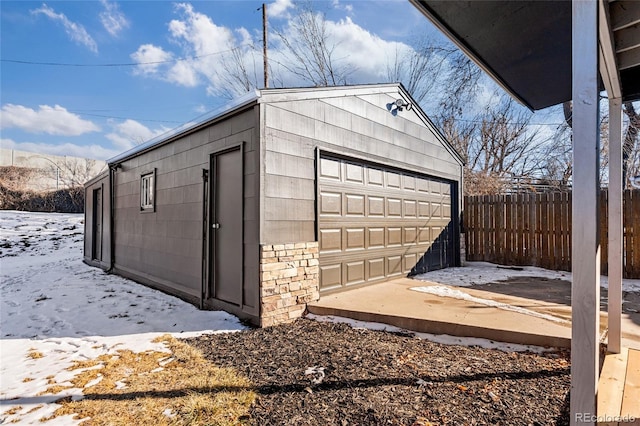 snow covered structure with a garage