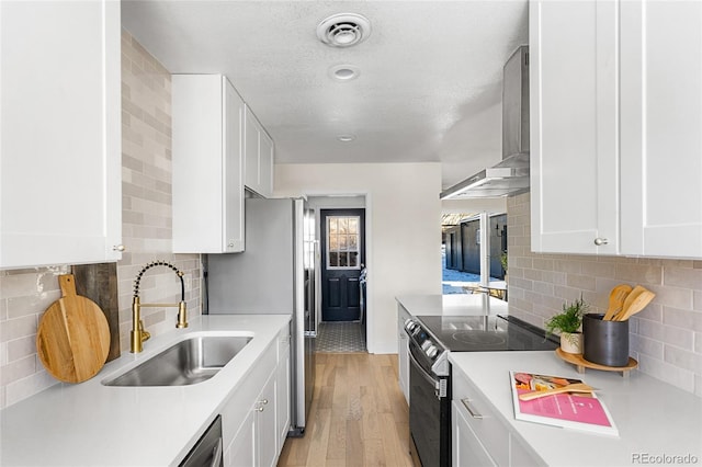 kitchen featuring white cabinetry, sink, light wood-type flooring, and appliances with stainless steel finishes