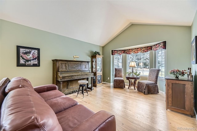 living area with lofted ceiling, light wood-style flooring, and baseboards