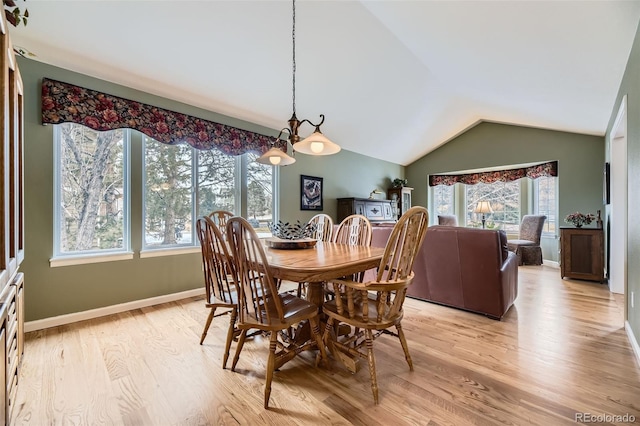 dining area featuring vaulted ceiling, baseboards, and light wood-style floors