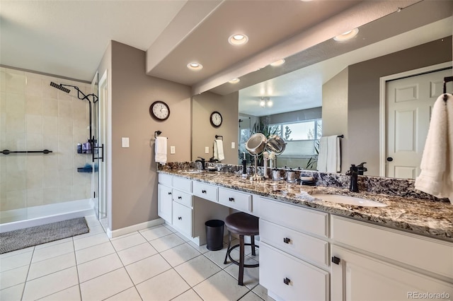 full bathroom featuring double vanity, a shower stall, tile patterned floors, and a sink