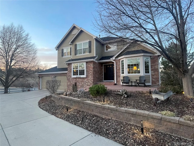 view of front of property featuring a garage, brick siding, and driveway