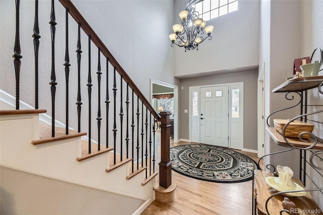 2522 W Dry Creek Ct, Littleton, CO 80120 - foyer with wood finished floors, stairway, a high ceiling, a chandelier, and baseboards